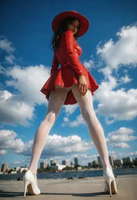 Woman in Red Standing Under Sky